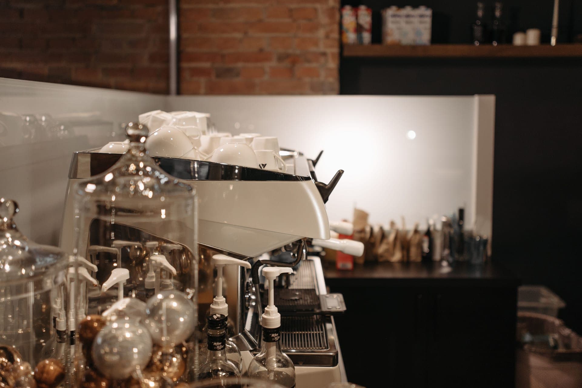 A home espresso and coffee setup lit warmly against a near-black background
