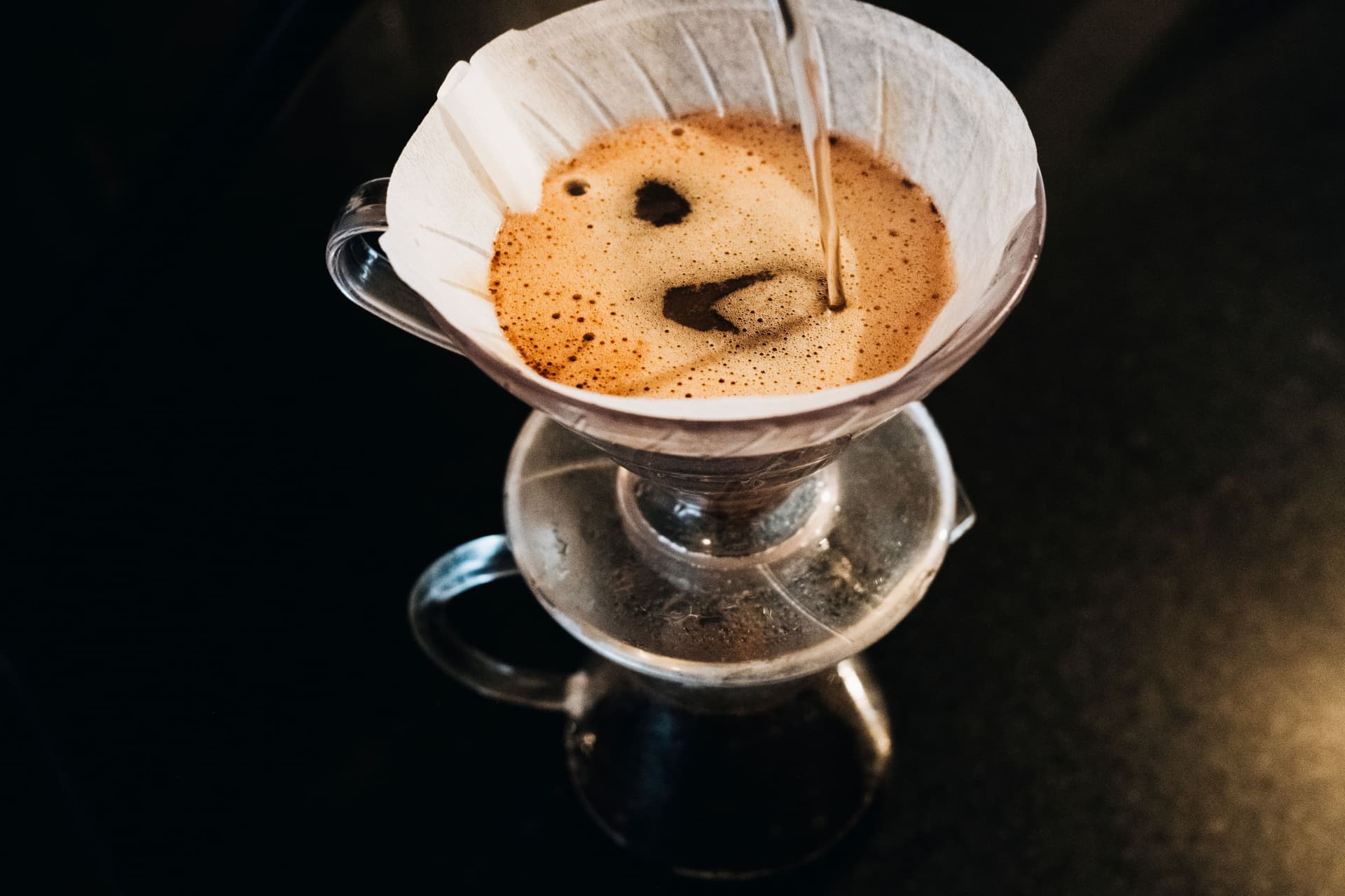 Pour-over coffee being brewed over a dark background