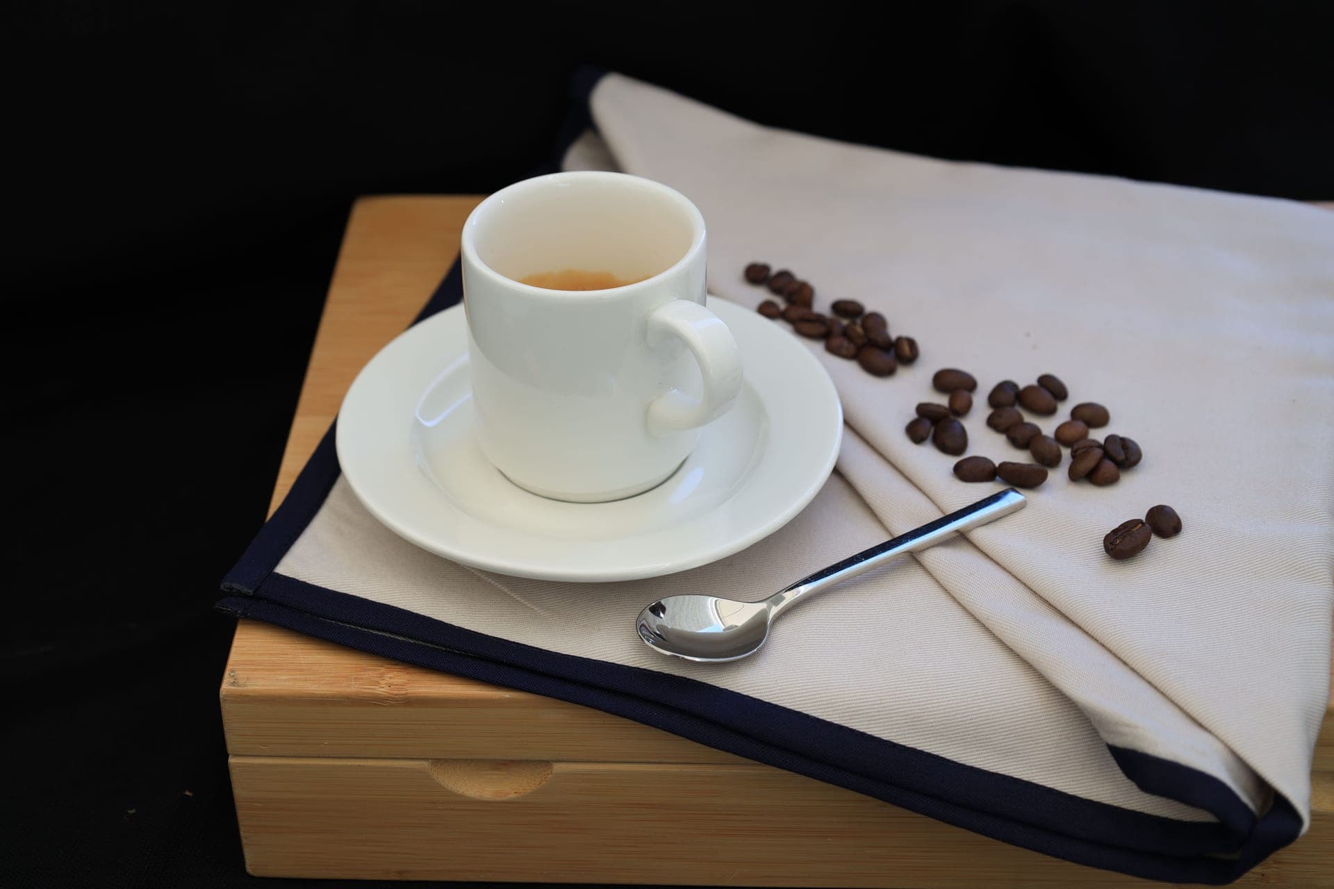 A wrapped gift beside a cup of coffee on a dark surface